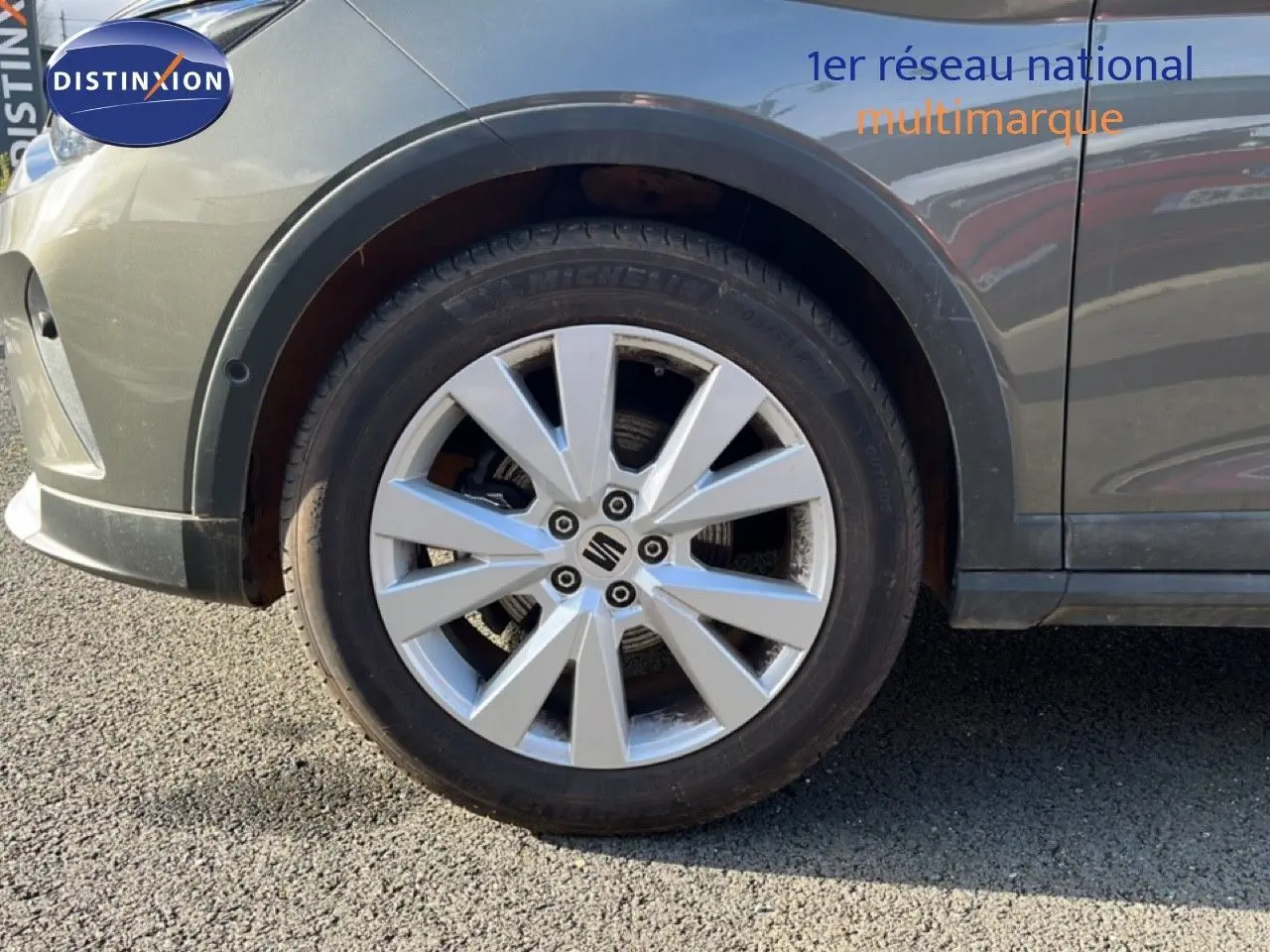 Gros plan sur la roue avant gauche d’un SEAT Arona gris magnétique métal avec jante alliage 17 pouces.
