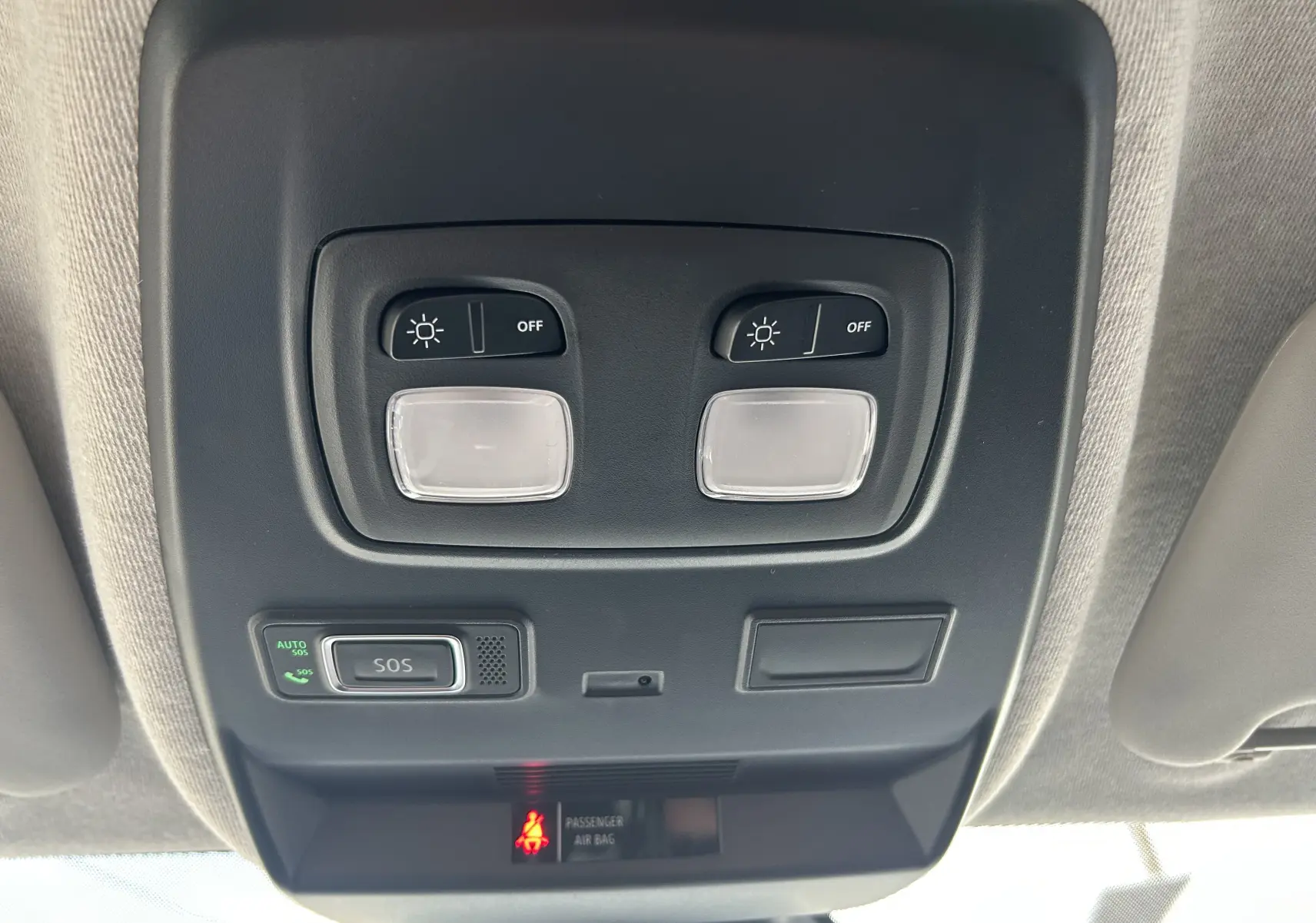 Vue en gros plan du plafonnier noir avec éclairages et bouton SOS du Renault Trafic Fourgon blanc, intérieur clair.
