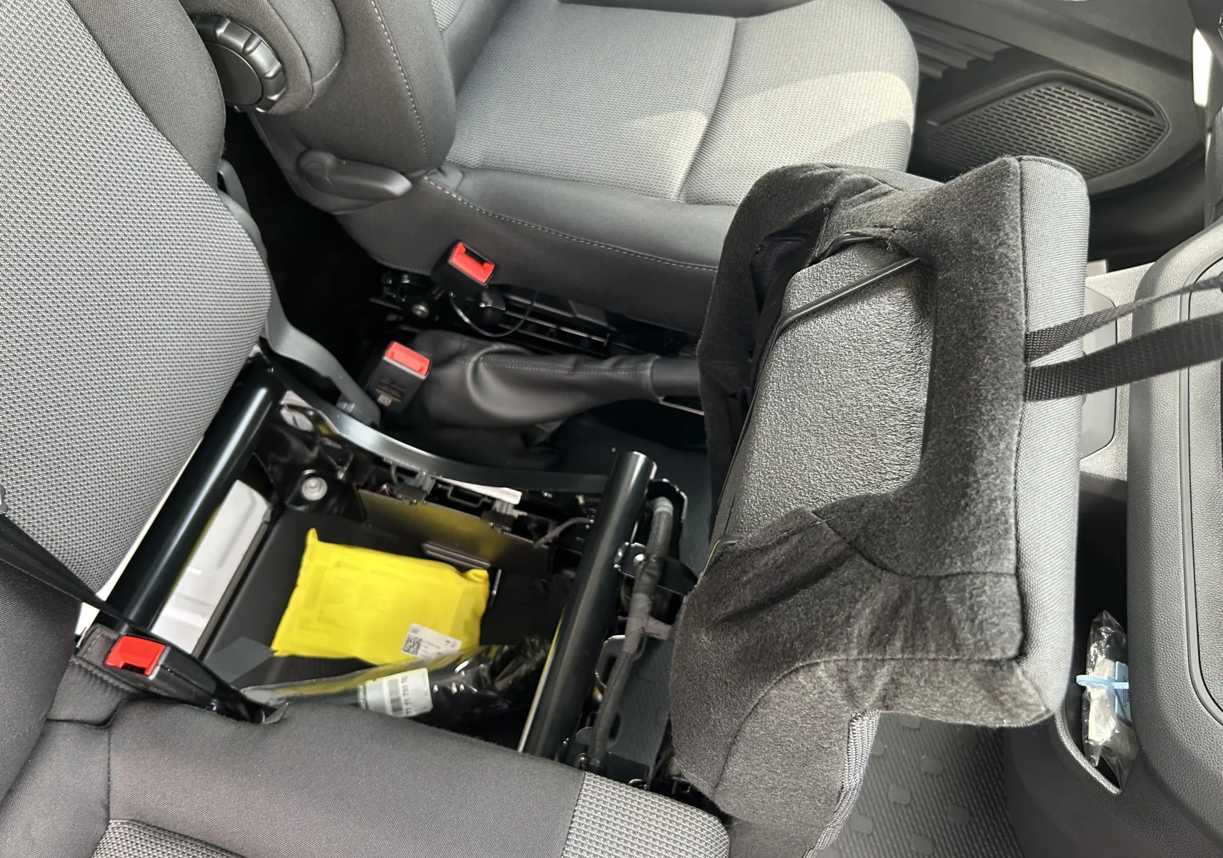Vue intérieure rapprochée du siège passager avant relevé du Renault Trafic Fourgon blanc, montrant la banquette et le rangement dessous.