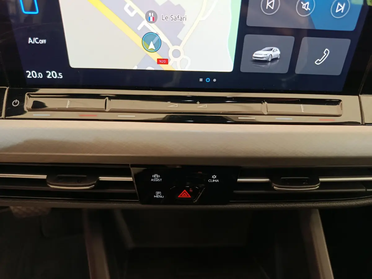 Détail du tableau de bord gris clair de la Volkswagen Golf 2022 avec écran tactile et commandes climatisation intégrées.