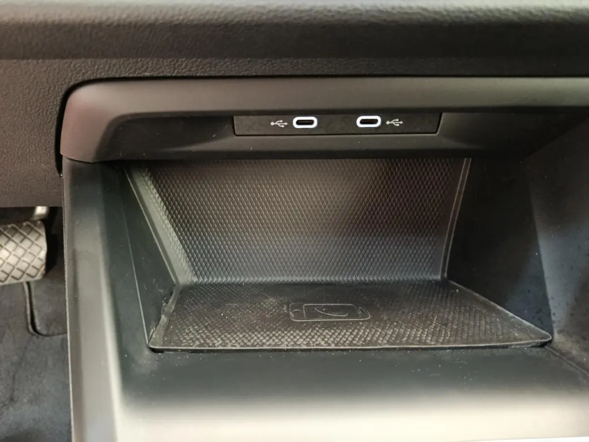Espace de recharge sans fil et double port USB-C dans la console centrale d'une Volkswagen Golf gris foncé 2022.