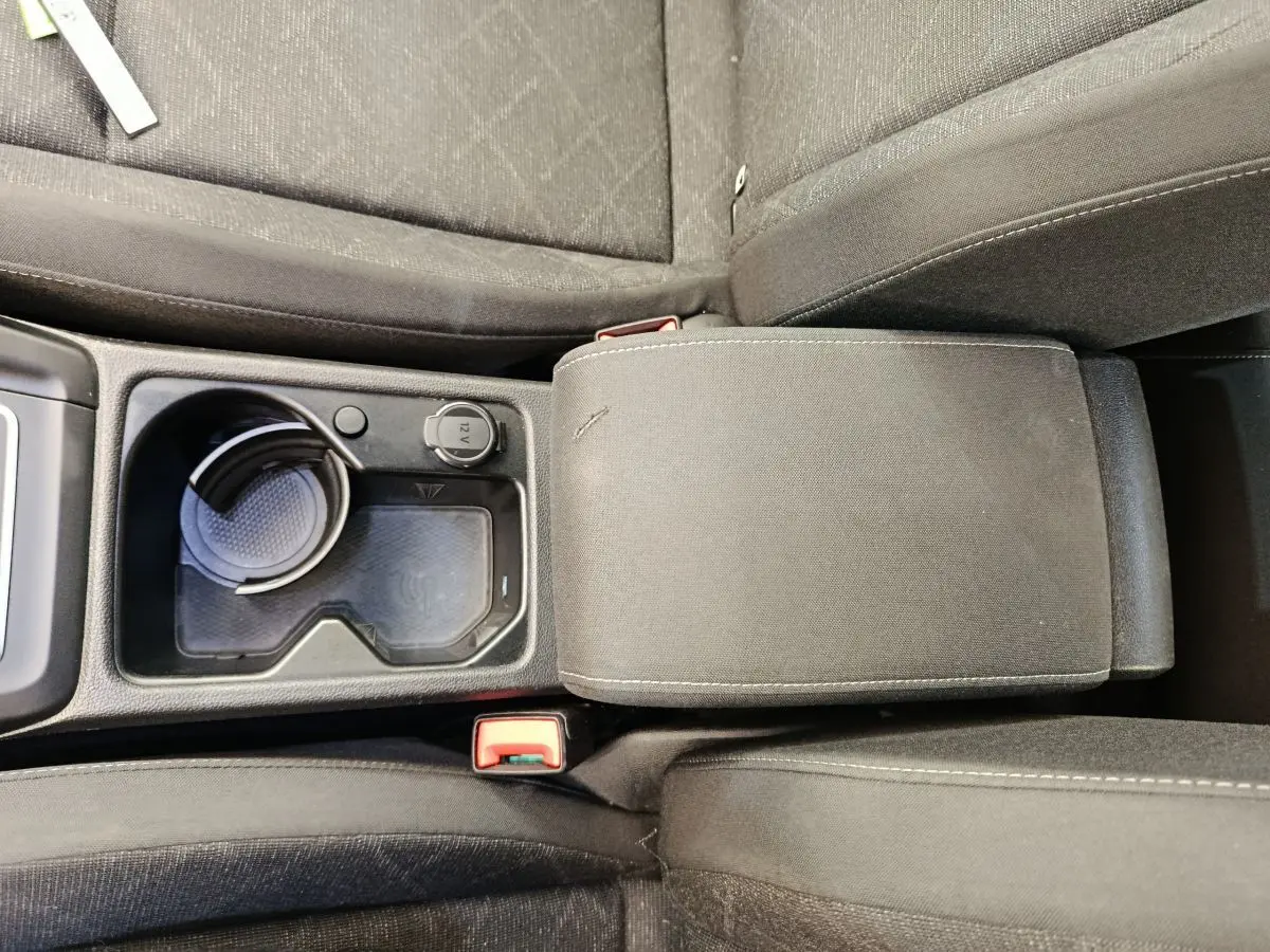 Gros plan sur la console centrale et accoudoir en tissu gris foncé de la Volkswagen Golf 2022.