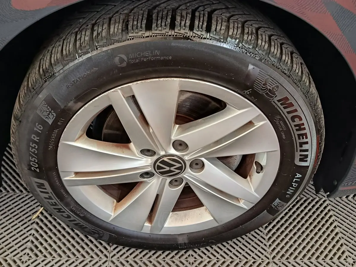 Gros plan sur la roue avant droite d'une Volkswagen Golf gris foncé avec jante alliage et pneu Michelin hiver.