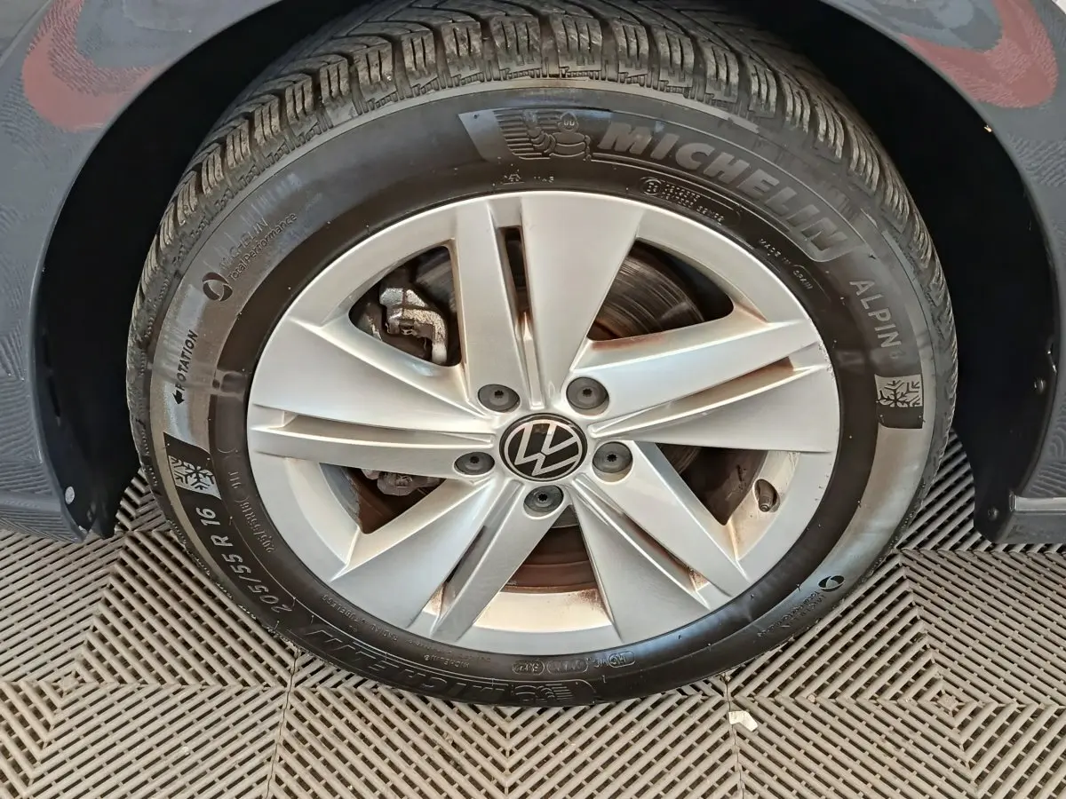 Gros plan sur la roue avant gauche d'une Volkswagen Golf gris foncé avec jante alliage et pneu Michelin hiver.
