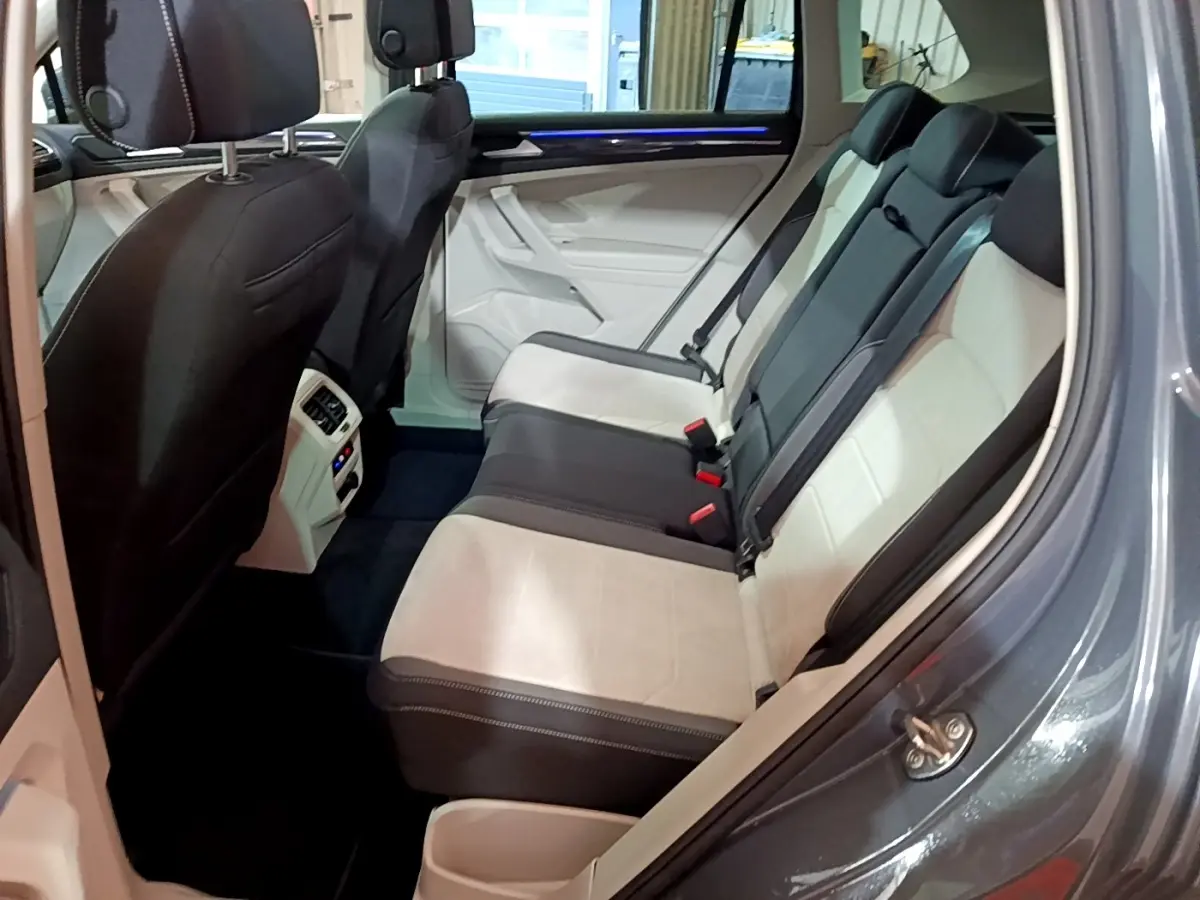 Vue intérieure côté droit des sièges arrière bicolores beige et noir du Volkswagen Tiguan gris clair 2022.