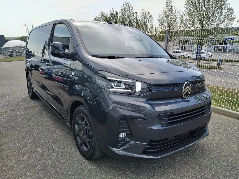 Vue 3/4 avant du Citroën Jumpy Cabine Approfondie gris titane avec roues tôlées noires et portes latérales coulissantes.