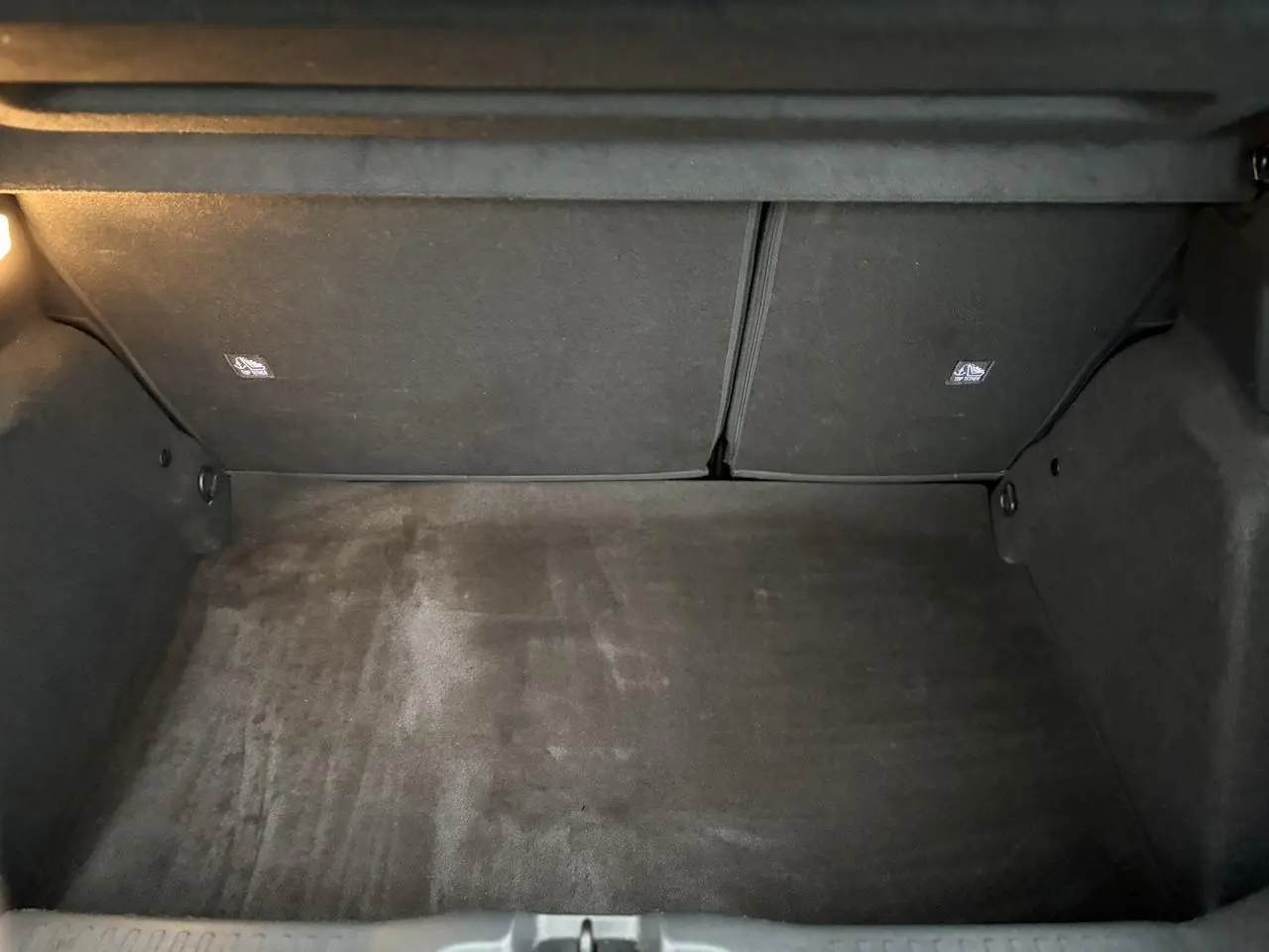 Coffre vide de Citroën C3 Turbo 100 Max 2025, vue intérieure avec tapis noir et éclairage latéral.
