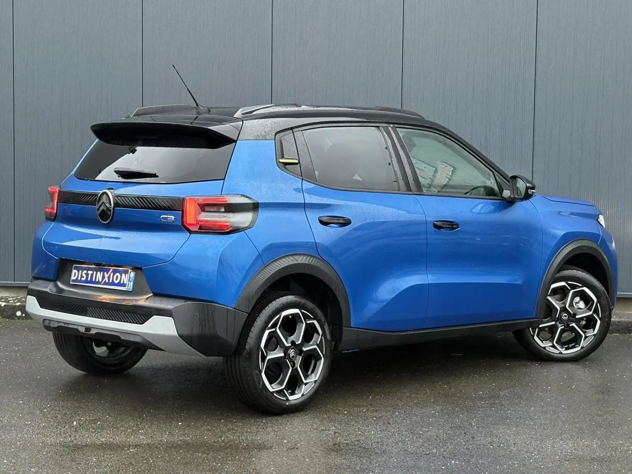 Vue 3/4 arrière droite d'une Citroën C3 2025 Bright Blue avec toit noir et jantes alliage 17 pouces.