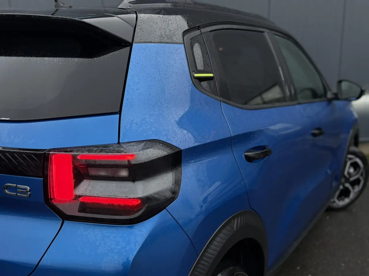 Vue 3/4 arrière droite d'une Citroën C3 2025 Bright Blue avec toit noir Perla Nera et feux arrière LED 3D.