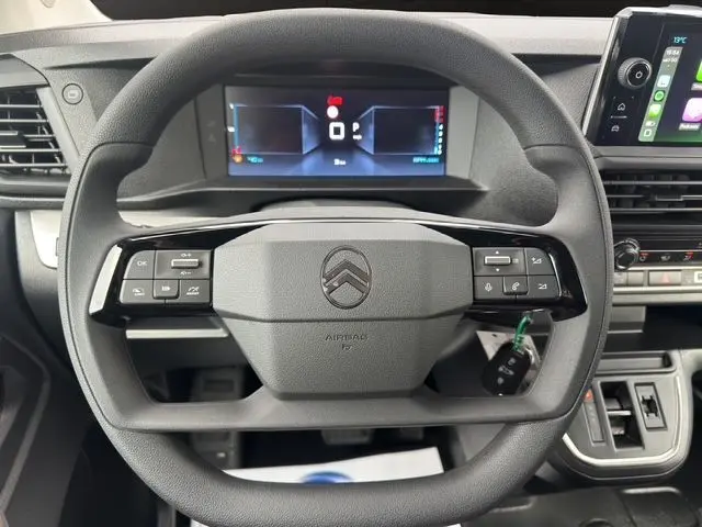 Vue rapprochée du volant noir du Citroën Jumpy 2025 avec commandes intégrées et tableau de bord numérique.