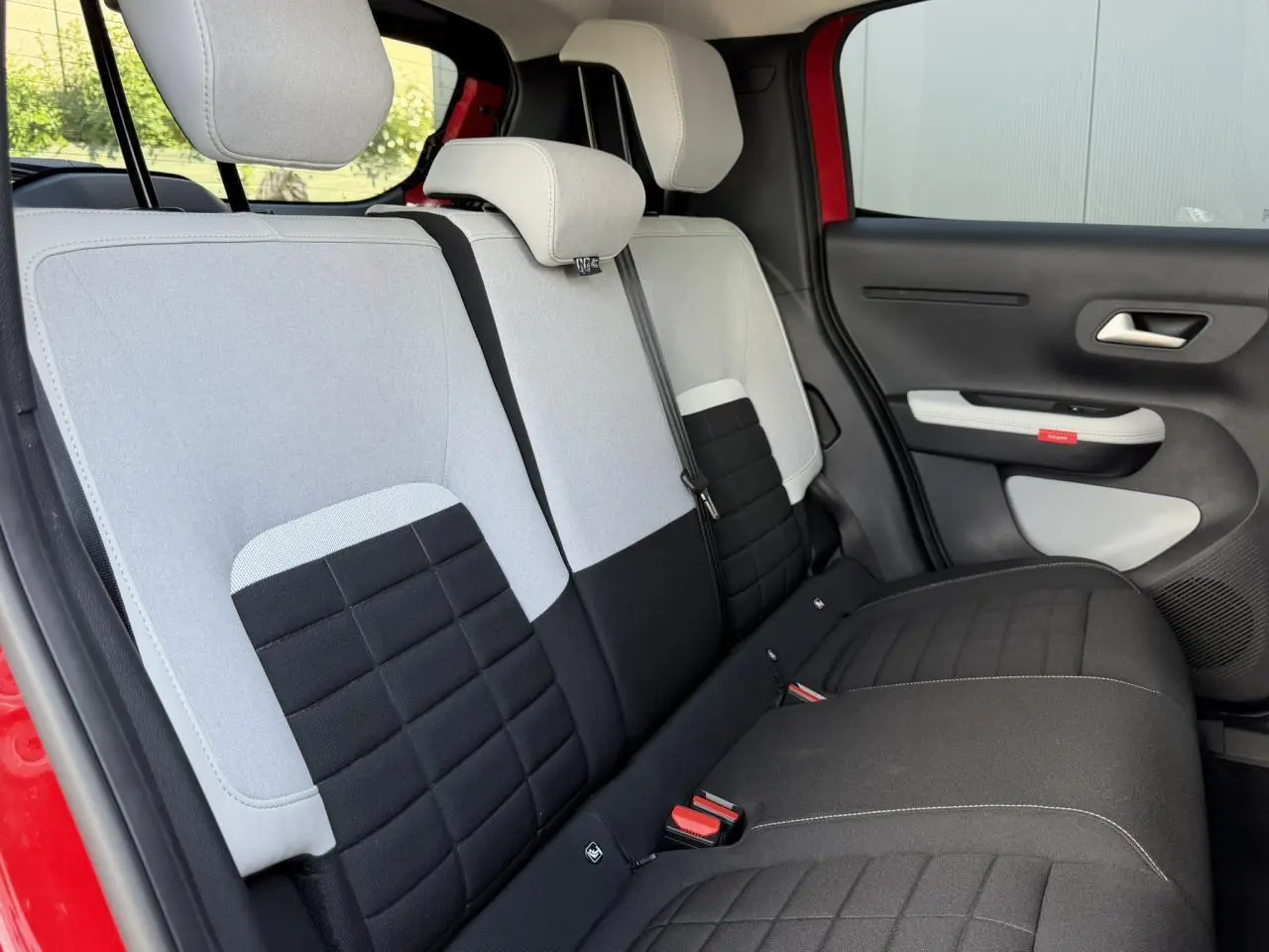 Vue intérieure côté droit des sièges arrière bicolores gris clair et noir d'une Citroën C3 Rouge Elixir.