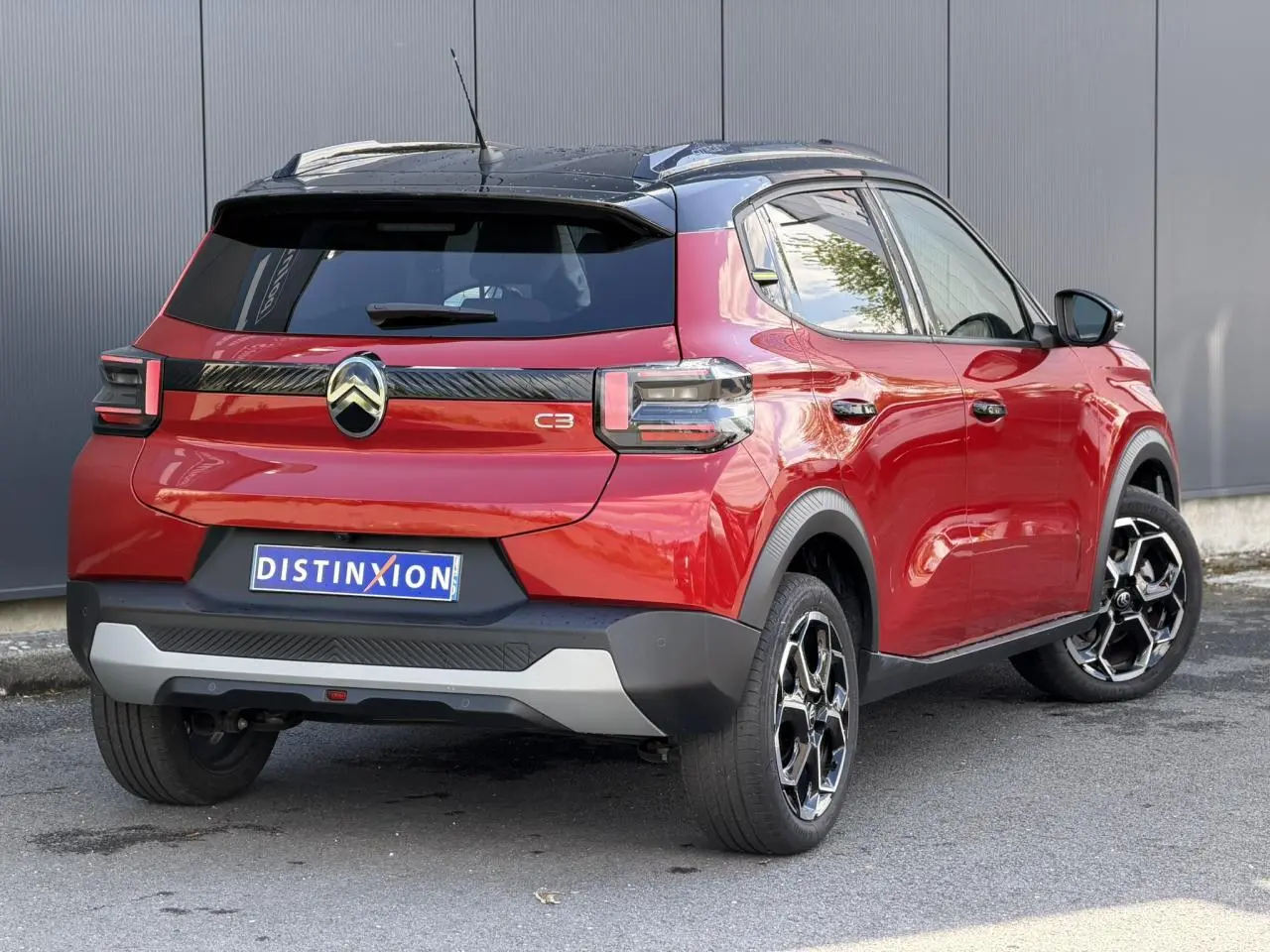 Vue 3/4 arrière droite d'une Citroën C3 Rouge Elixir avec toit noir et jantes alliage 17 pouces.
