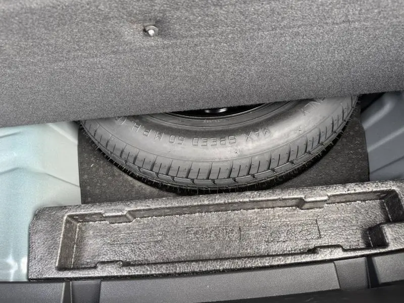 Vue rapprochée du coffre du Renault Arkana 2025 montrant la roue de secours et le rangement en mousse noire.