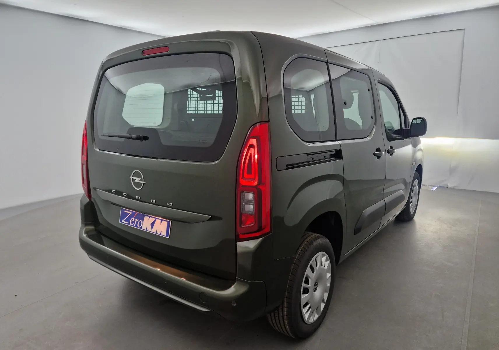 Vue 3/4 arrière droit d'un Opel Combo Life vert Sirkka avec vitrage arrière et grille de séparation visible.