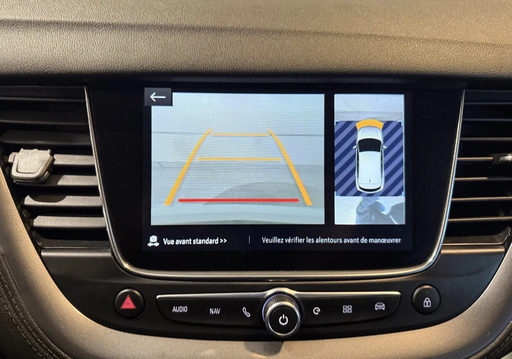 Écran central de l’Opel Grandland X blanc montrant la caméra avant avec lignes de guidage et vue 360° du véhicule.