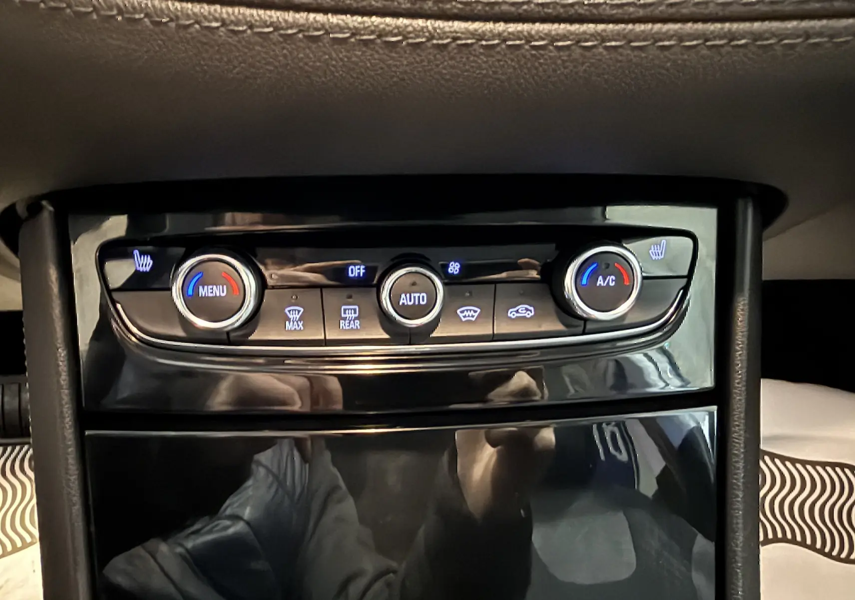 Gros plan sur la console centrale de l’Opel Grandland X blanc, montrant les commandes de climatisation et sièges chauffants.