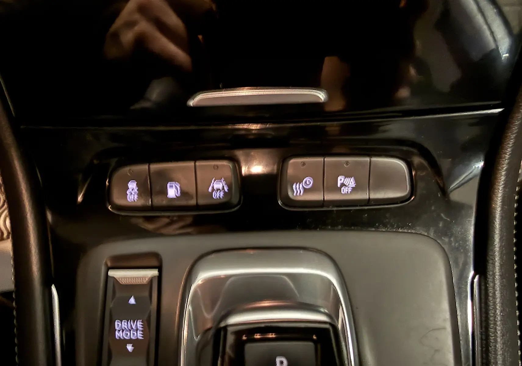 Gros plan sur la console centrale de l’Opel Grandland X blanc, montrant les boutons de modes de conduite et assistances.