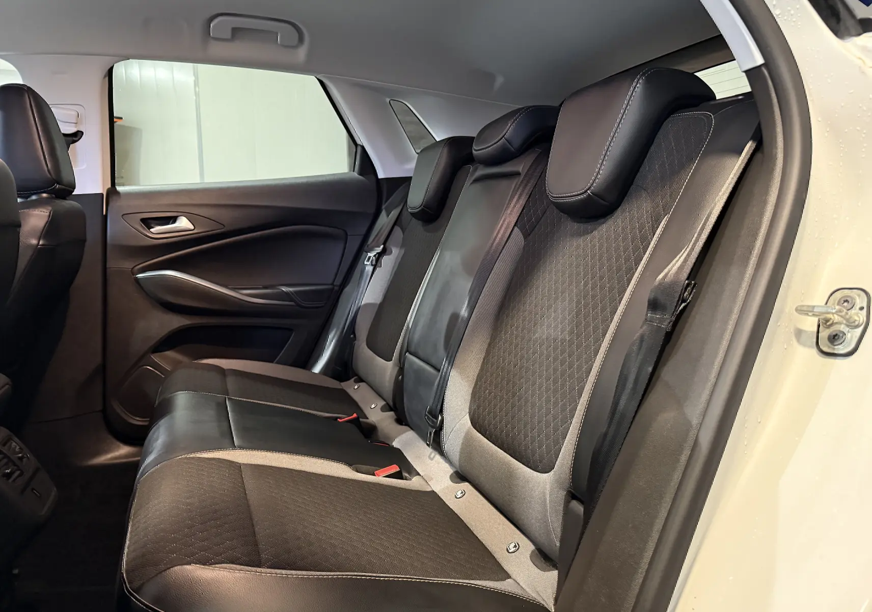 Vue intérieure côté droit des sièges arrière en tissu noir et cuir sur Opel Grandland X blanc 2021 hybride rechargeable.