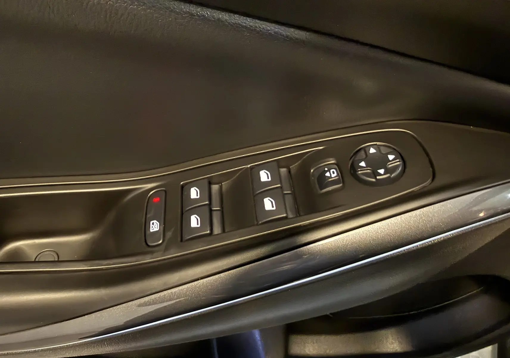 Gros plan sur les commandes de lève-vitres et réglage des rétroviseurs côté conducteur d’un Opel Grandland X 1.6 Hybrid Turbo blanc.