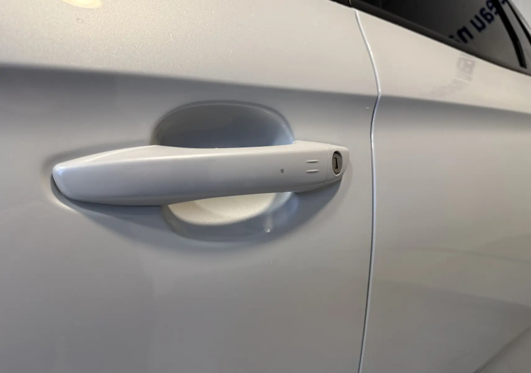Poignée de porte blanche côté droit de l'Opel Grandland X hybride rechargeable, finition lisse et moderne.