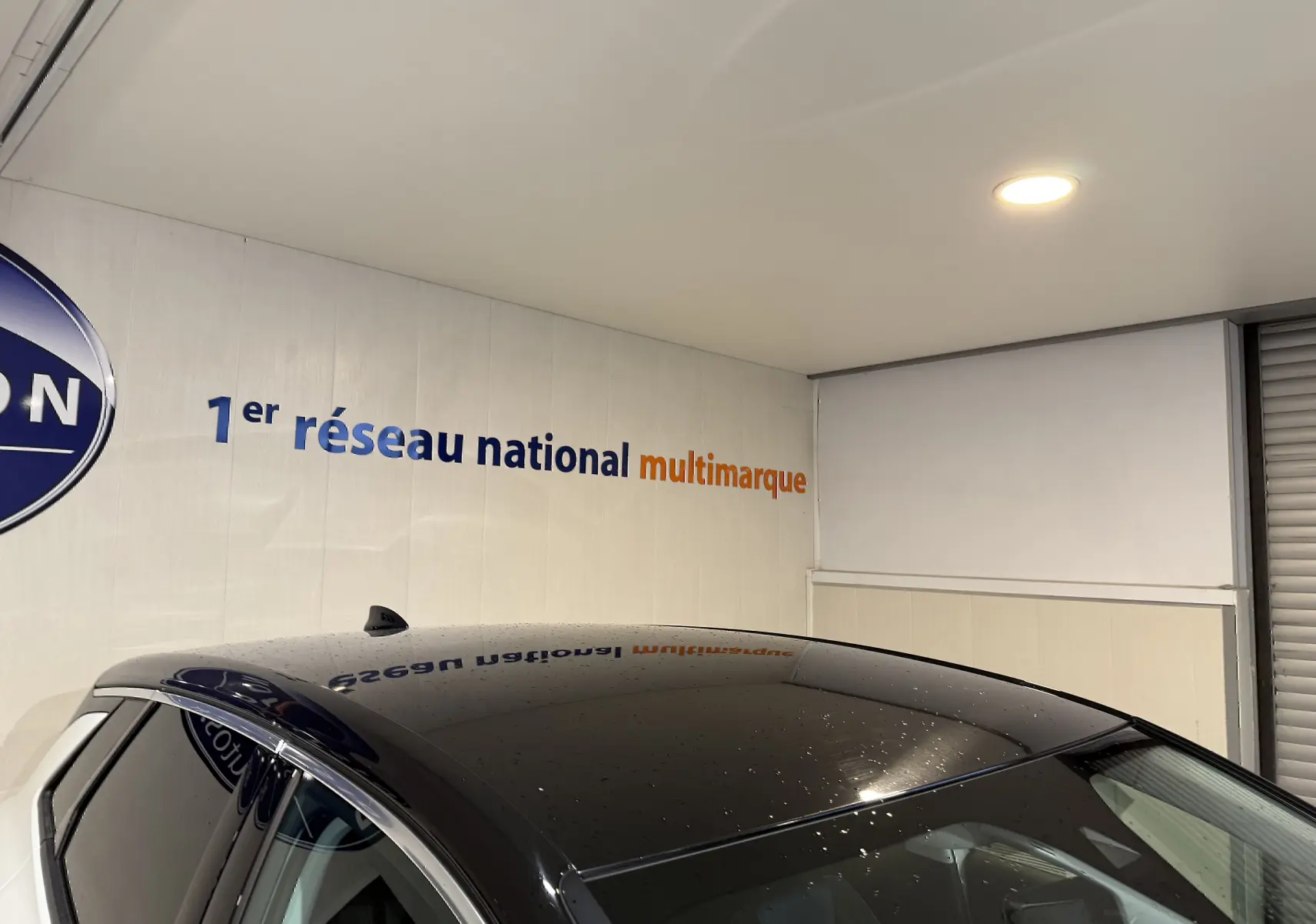 Toit noir brillant du SUV Opel Grandland X blanc vu en plongée depuis l'avant droit dans un showroom.