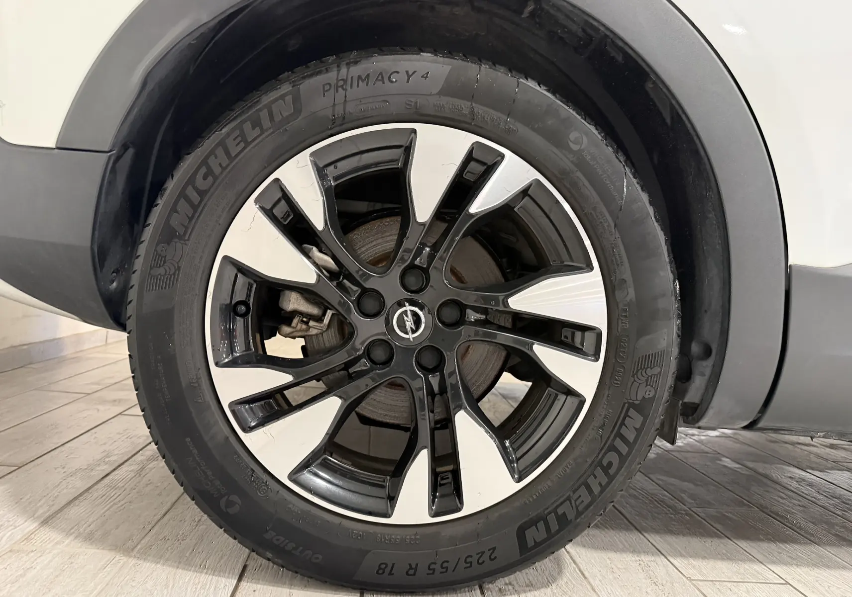 Gros plan sur la roue avant gauche d’un Opel Grandland X blanc avec jante alliage bicolore noire et argent.