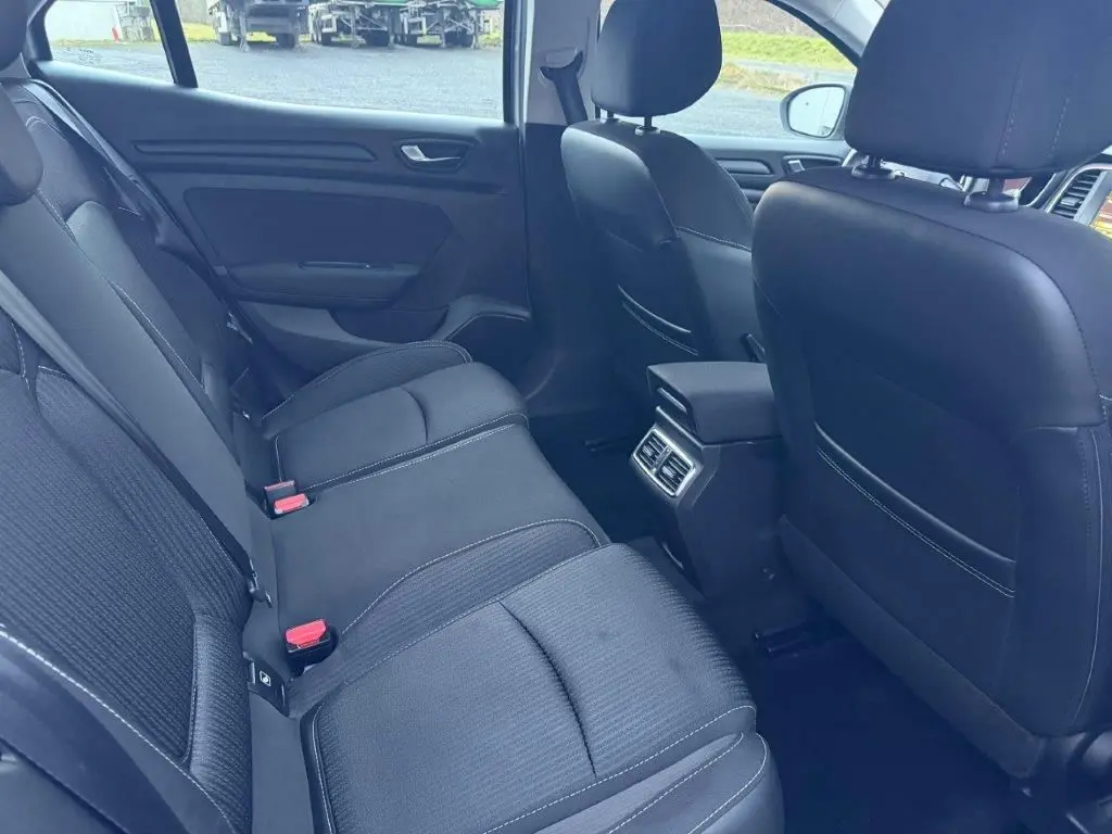 Vue intérieure arrière côté droit de la Renault Mégane Business gris alu, montrant les sièges arrière et les aérateurs centraux.