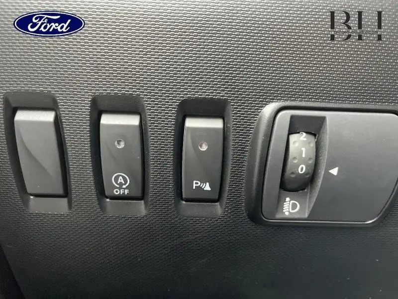 Tableau de bord avec commandes de régulation et réglage des phares d'une Renault Twingo Rouge Flamme vue de face.