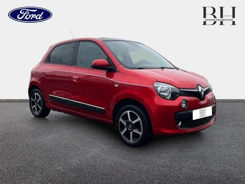 Renault Twingo Rouge Flamme vue 3/4 avant droit, toit ouvrant en toile et jantes alu distinctives visibles.