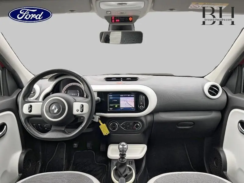 Vue intérieure avant de la Renault Twingo rouge Flamme 2019, tableau de bord avec écran tactile et volant cuir.