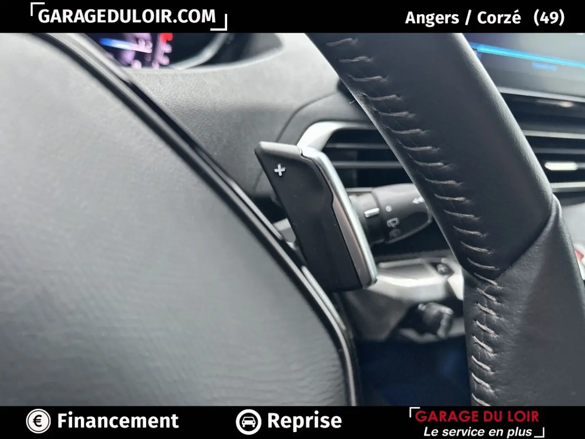 Gros plan sur la palette de changement de vitesse au volant en cuir noir du Peugeot 3008 blanc 2024.