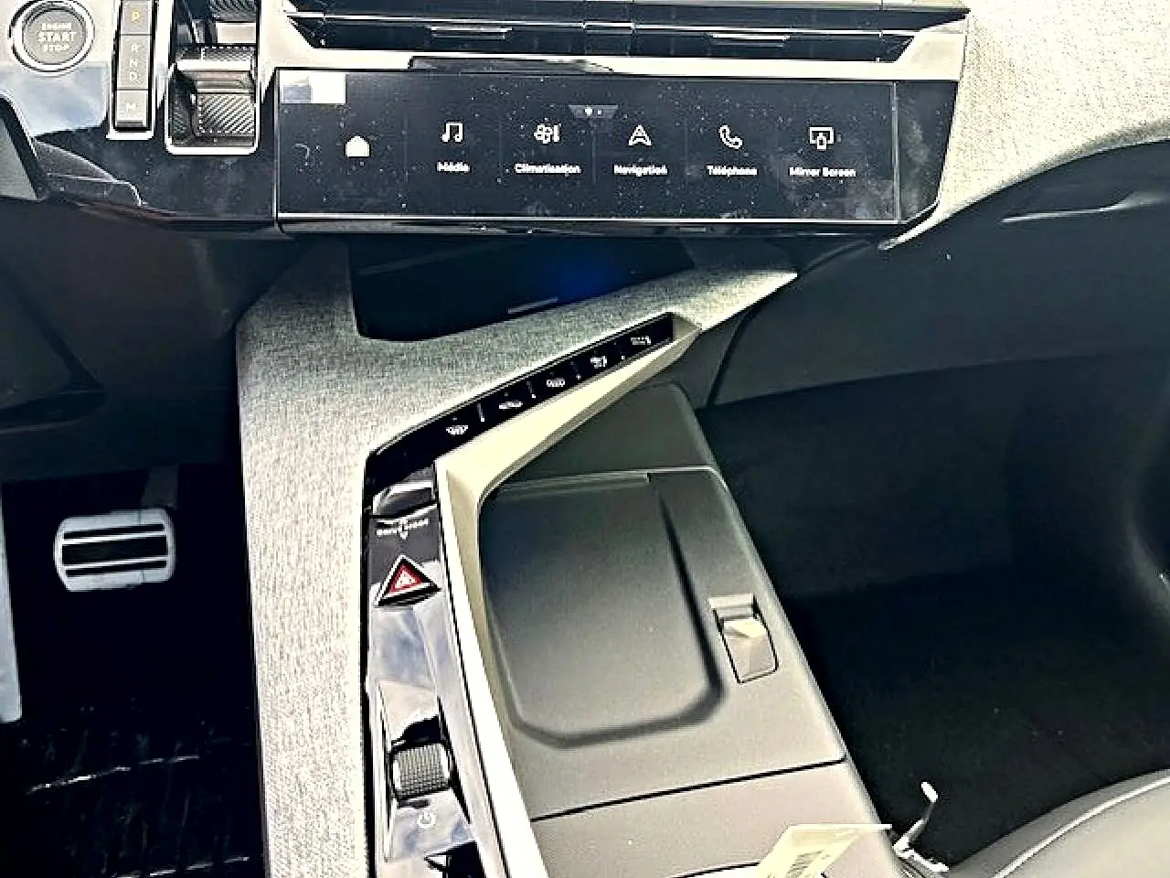 Vue rapprochée de la console centrale grise et noire du Peugeot 3008 1.2 hybrid 136 GT avec écran tactile et commandes intégrées.