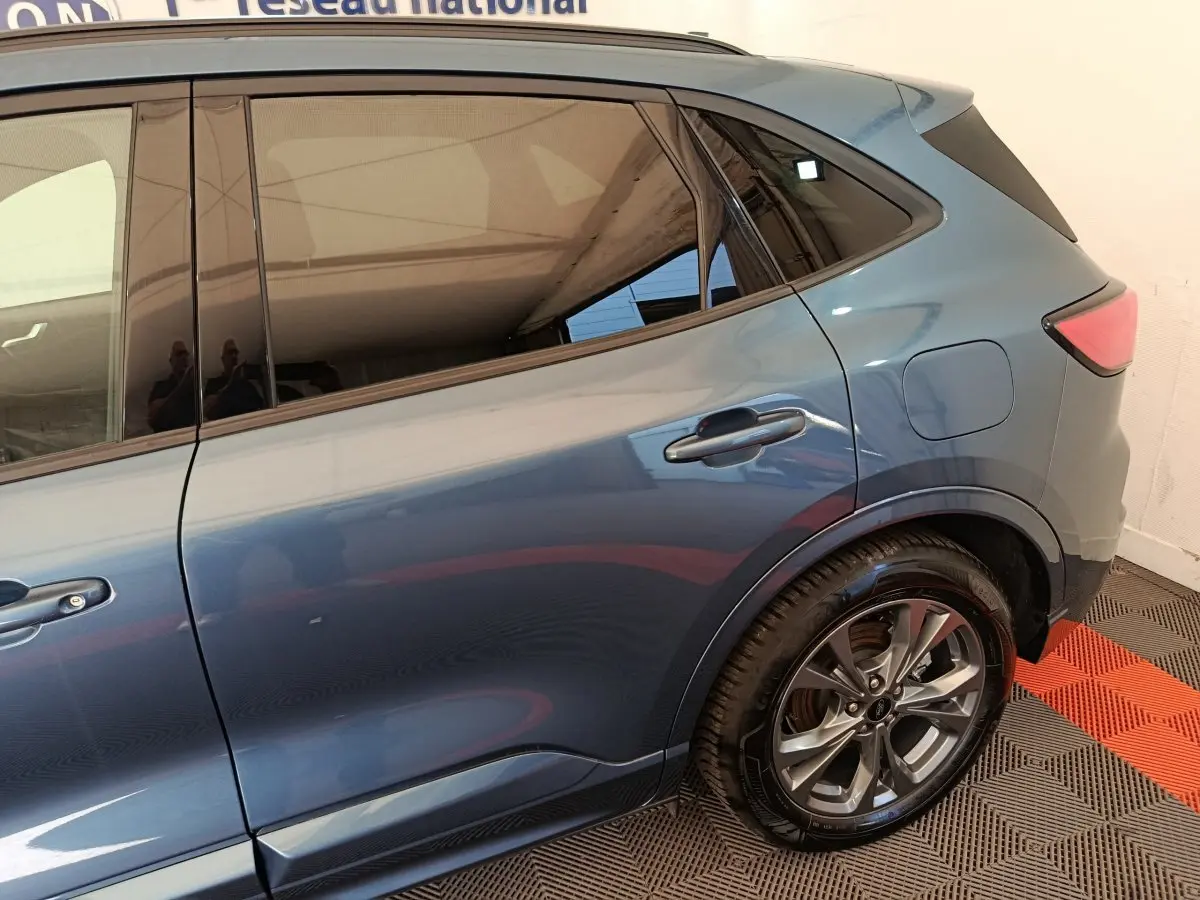 Vue latérale droite du Ford Kuga bleu 2024, mettant en valeur la porte arrière et la jante alliage moderne.