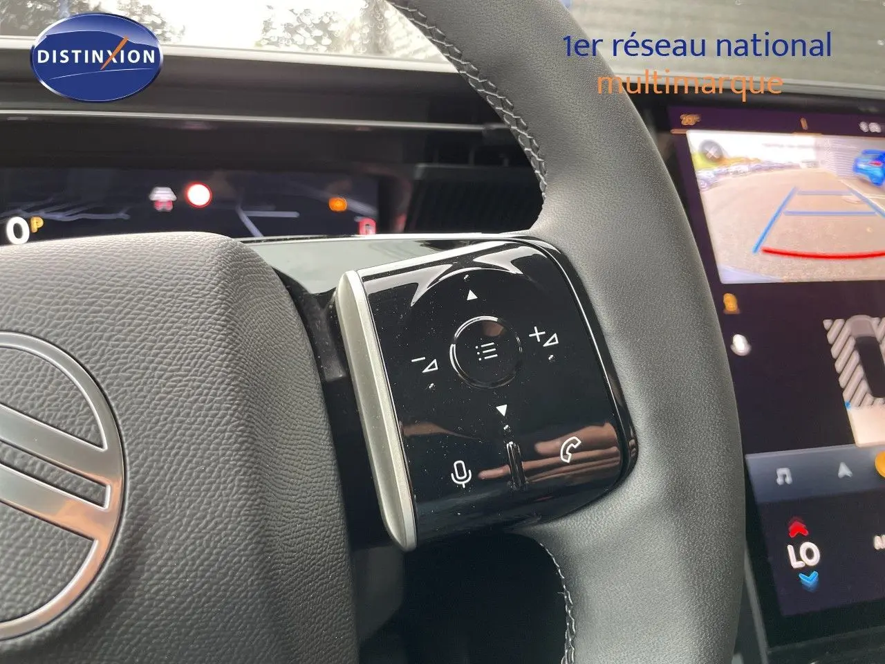 Gros plan sur le volant cuir noir du Citroën C5 Aircross gris platinium, avec commandes tactiles et écran multimédia en arrière-plan.
