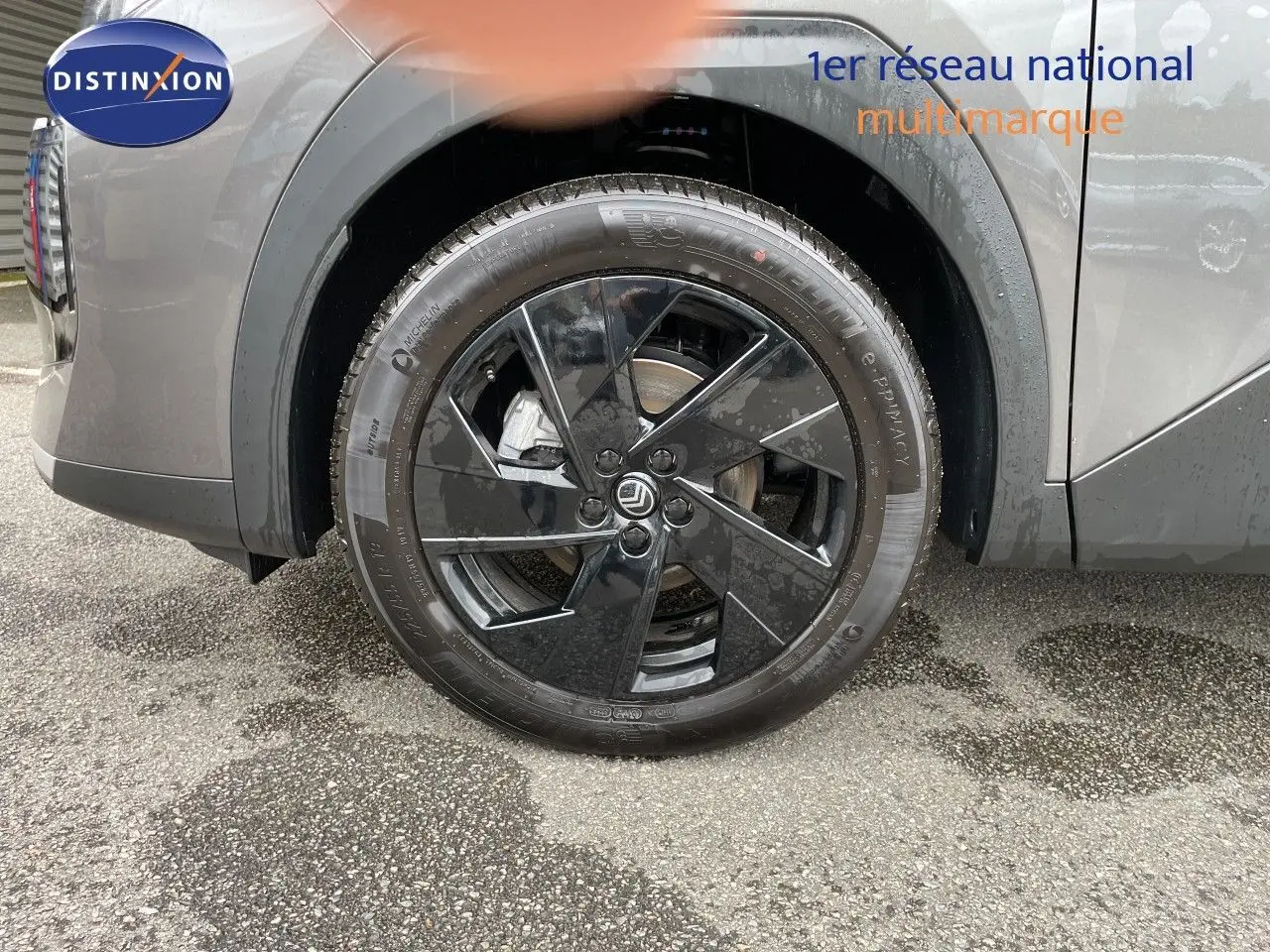 Gros plan sur la roue avant gauche noire brillante du Citroën C5 Aircross gris platinium métal.