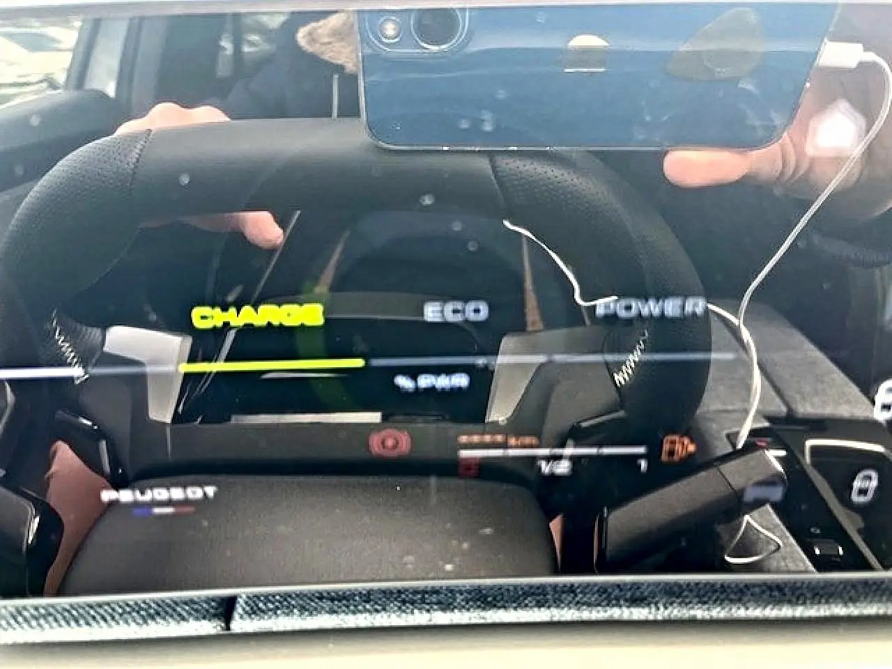 Vue rapprochée du tableau de bord numérique du Peugeot 3008 gris, affichant les modes Charge, Eco et Power.
