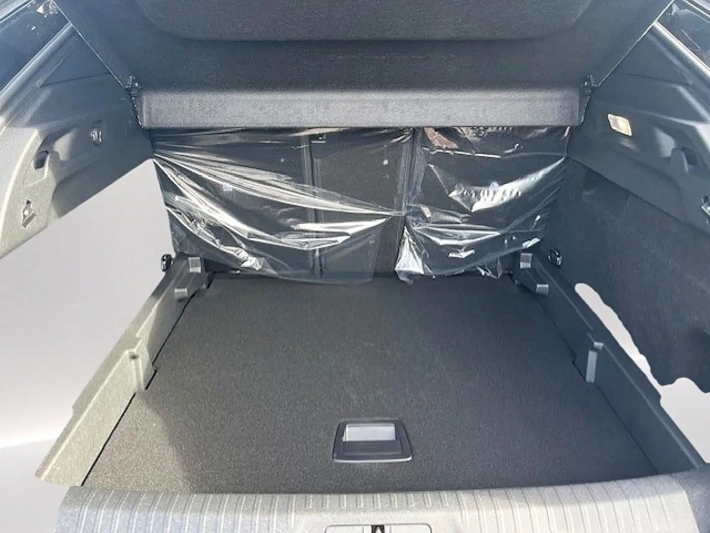 Coffre ouvert du Peugeot 3008 gris Artense, vue de l'intérieur montrant le plancher plat et les protections plastiques.