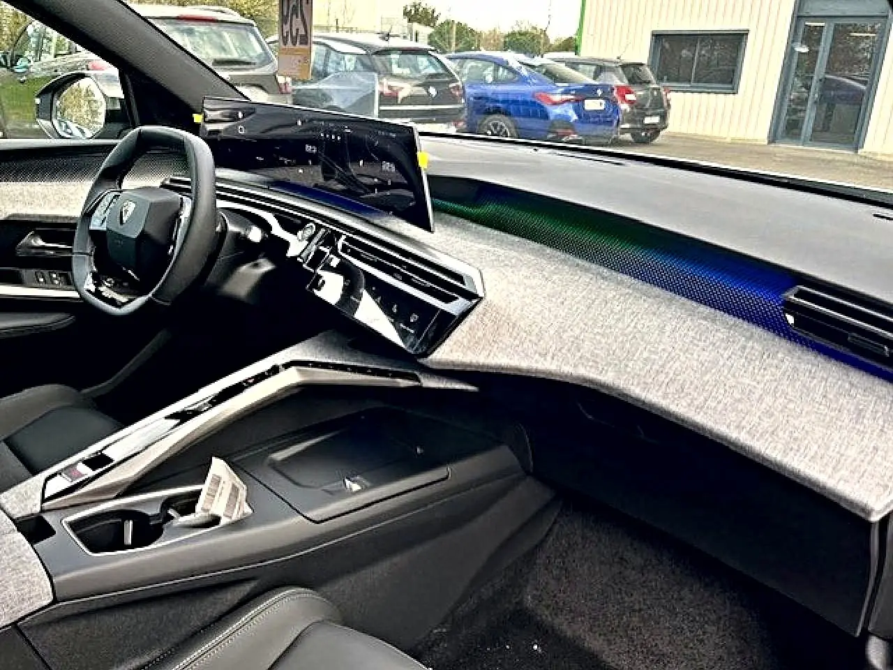 Vue intérieure côté conducteur du Peugeot 3008 gris Artense, avec tableau de bord moderne et écran tactile incurvé.