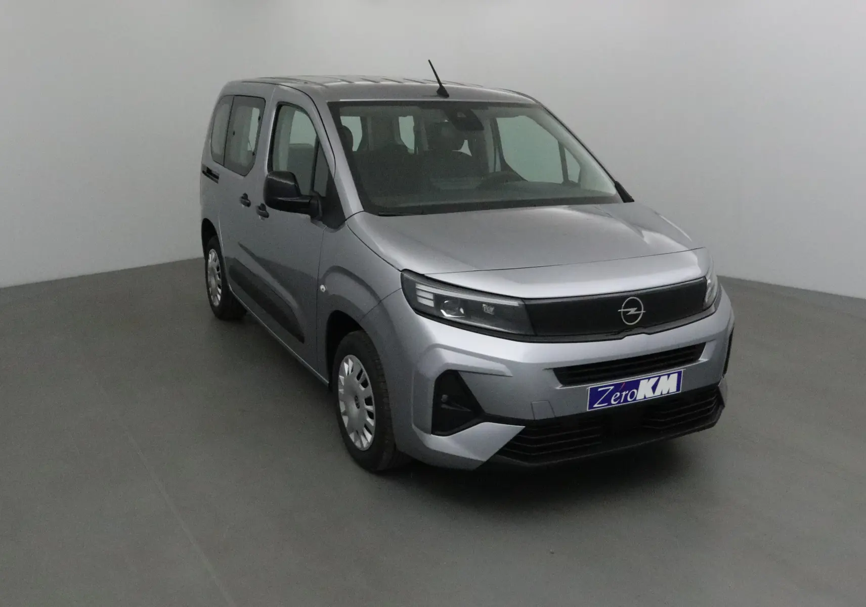 Opel Combo Life gris Artense vu en 3/4 avant gauche dans un studio, avec calandre noire et jantes acier.