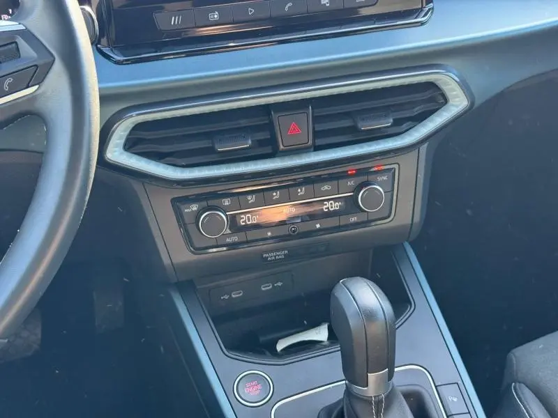 Vue rapprochée du tableau de bord et console centrale du SEAT Arona noir, avec commandes climatisation et levier de boîte auto.