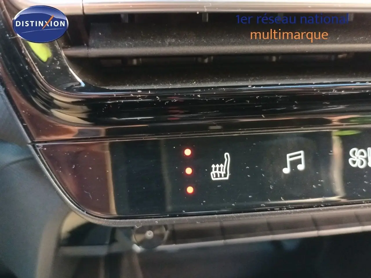 Détail du panneau de commande tactile noir avec icône de siège chauffant activé dans une Citroën C5 Aircross gris platinium.