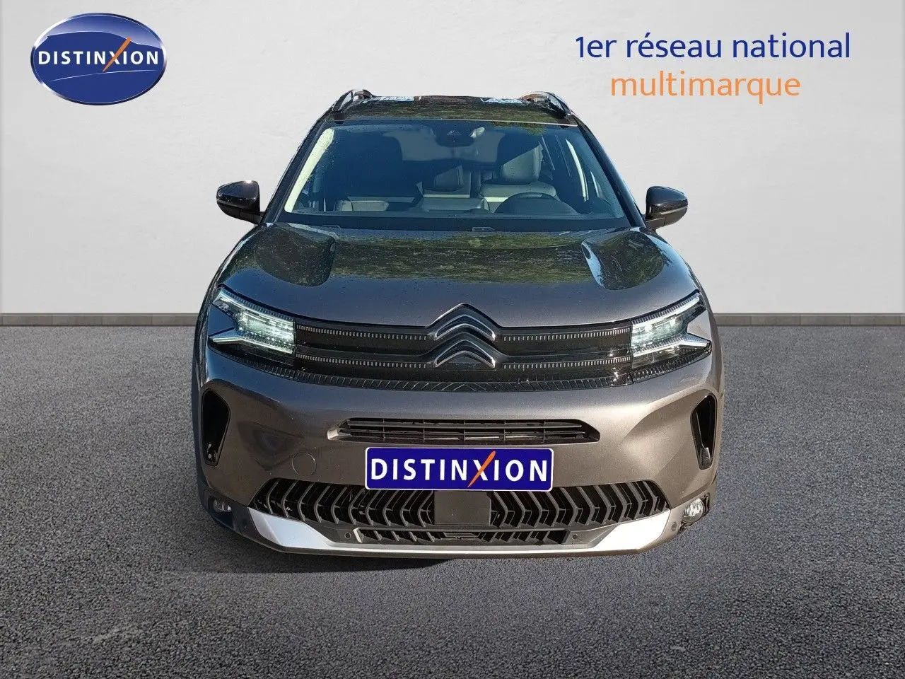 Vue avant centrée du Citroën C5 Aircross gris platinium métal avec calandre noire et phares LED allumés.