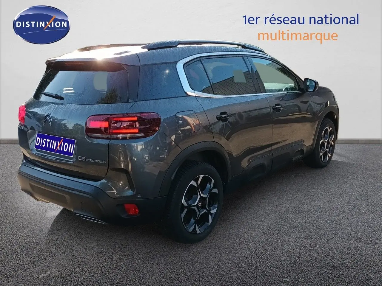 Citroën C5 Aircross gris platinium métal en 3/4 arrière droit, avec jantes bi-ton et feux LED allumés.