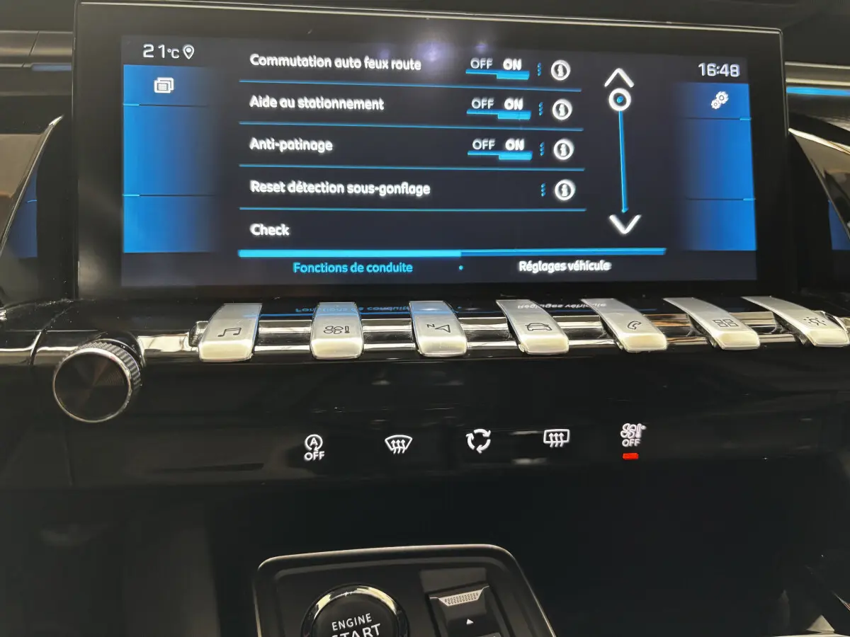 Écran tactile central et rangée de boutons métalliques dans l'habitacle d'une Peugeot 508 gris foncé de 2019.