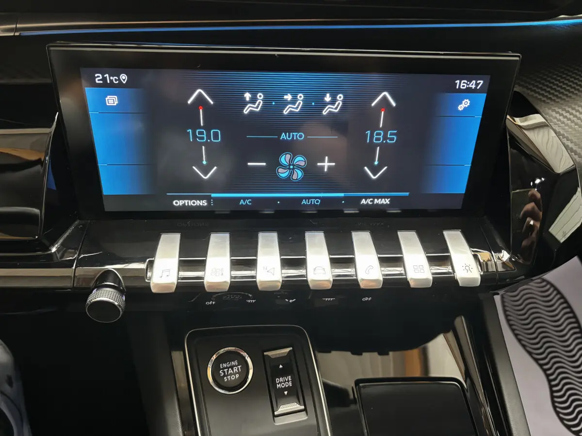 Gros plan sur la console centrale de la Peugeot 508 gris foncé, avec écran tactile et commandes en métal brossé.