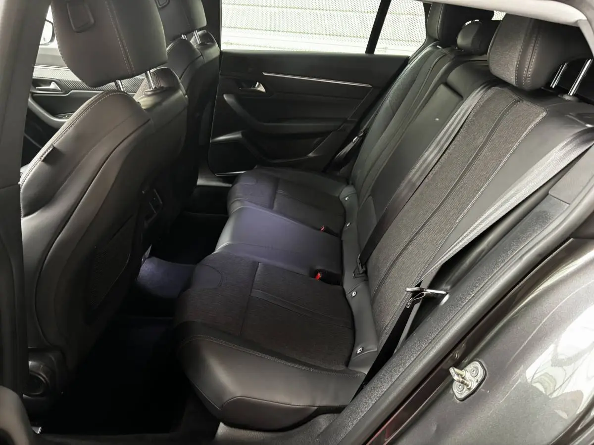 Vue côté droit de l'habitacle arrière d'une Peugeot 508 gris foncé, sièges en cuir et tissu noir.