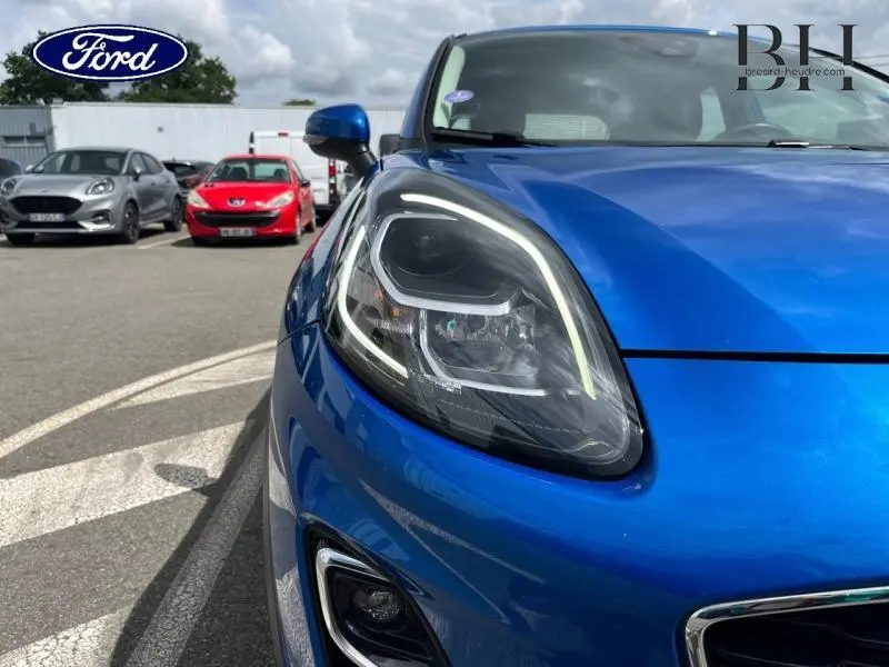 Gros plan sur le phare avant gauche du Ford Puma 2022 en bleu Fashion Bleu Island Métallisée, soulignant ses lignes modernes.