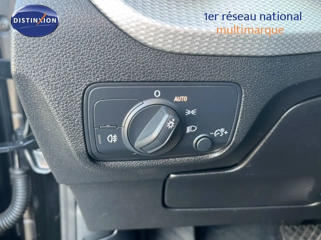 Gros plan sur le bouton de commande des phares dans l'habitacle noir de l'Audi Q2 35 TFSI S-Line 2023.
