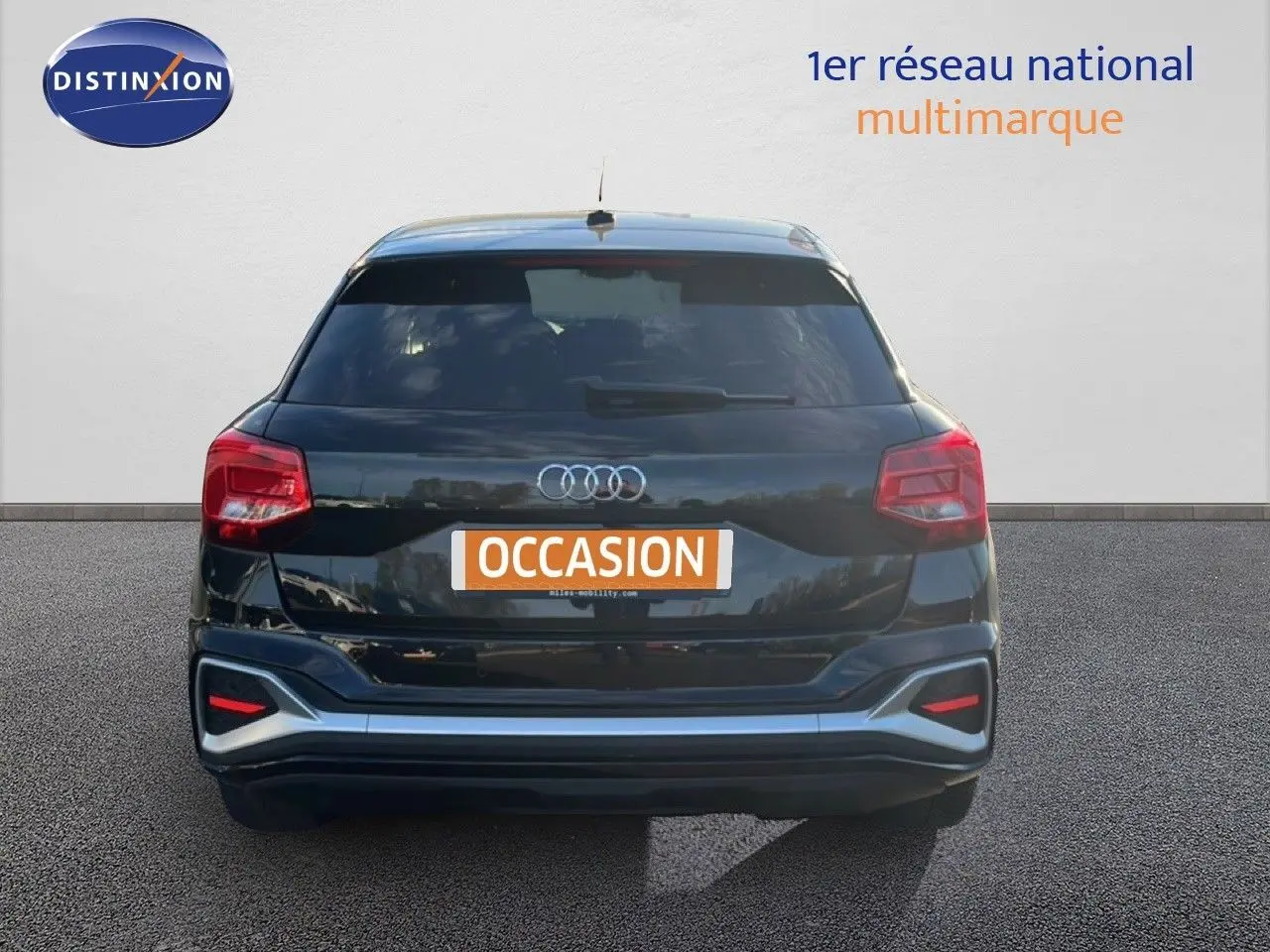 Vue arrière d'un Audi Q2 noir mito metal 2023 avec feux rouges et logo quatre anneaux bien visibles.