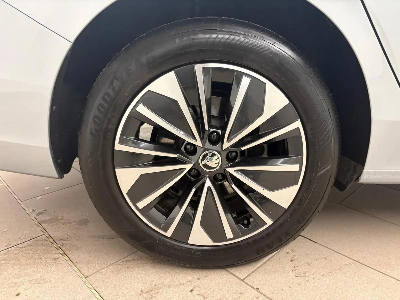 Gros plan sur la jante alliage bicolore et pneu Goodyear du côté gauche d’une Skoda Superb Combi gris argent 2025.
